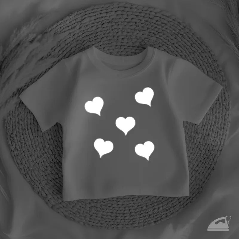 Reflexní nažehlovací srdíčka na oblečení pro zvýšení viditelnosti za špatného počasí.