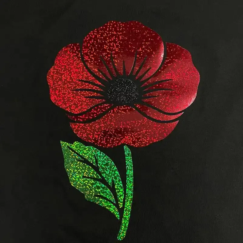 Holografická nažehlovací fólie na textil s 3D efektem (Dae-Ha) - detail červené, zelené a černé barvy.