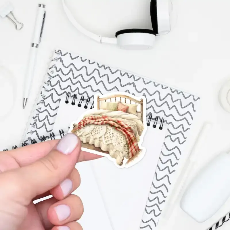 Samolepka do diáře postel s teplým pleteným přehozem.